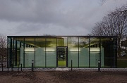 Textilbeton-Pavillon mit Glasfassade: Westansicht mit Eingang bei Dämmerung
