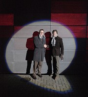 Prof. Gries und Dr. Roye stehen im Rampenlicht vor der neuen Fassade